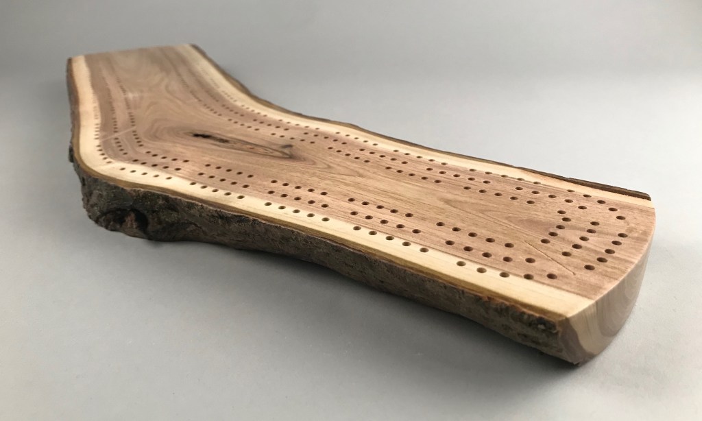 Low end view of live edge hardwood cribbage board #50